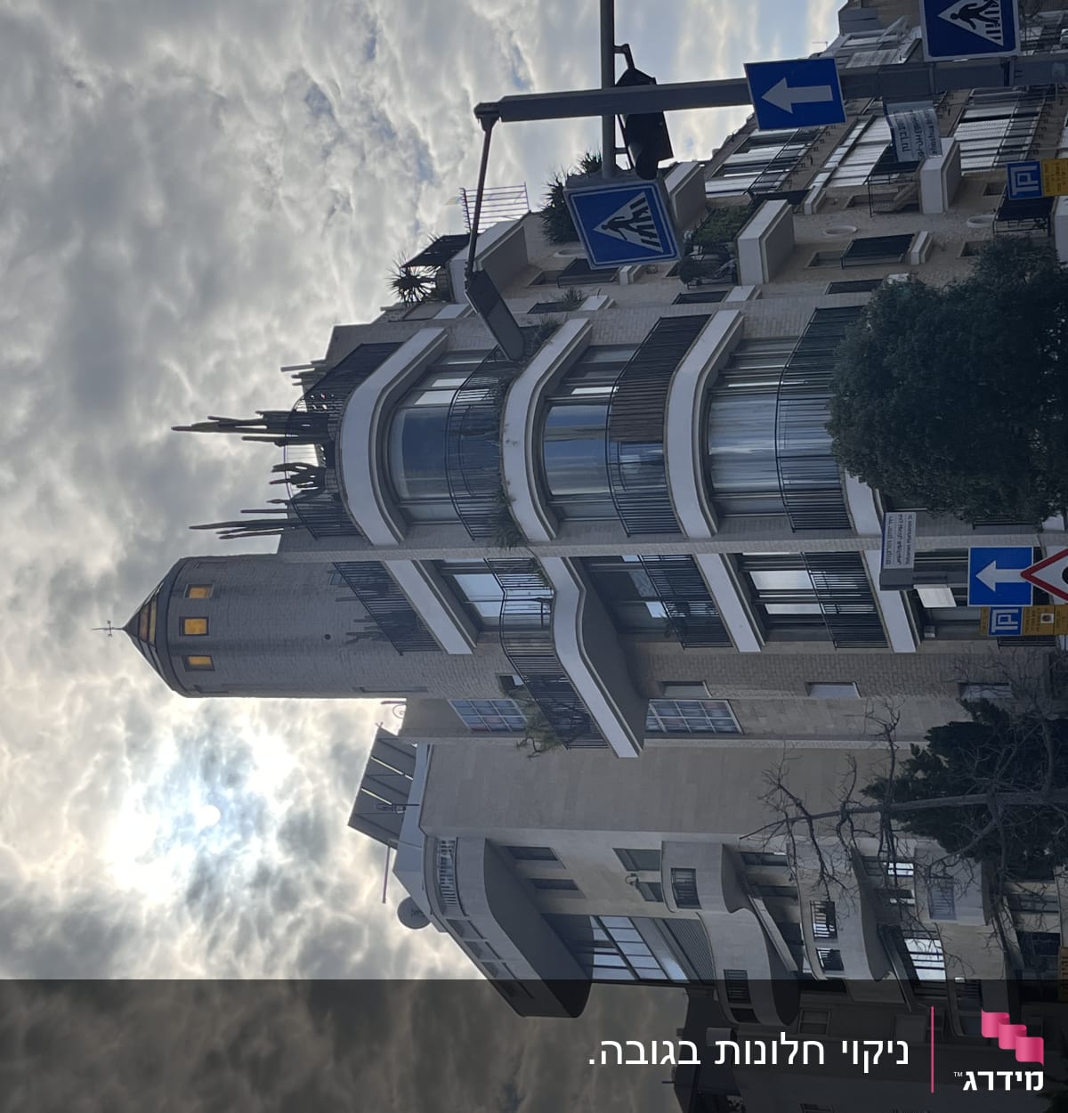 בניין גבוה עם חלונות גדולים ושלטי תנועה